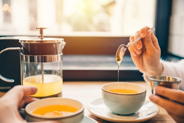 Mujer beber té de naranja caliente en la cafetería