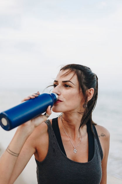 Mujer bebiendo agua después de un entrenamiento