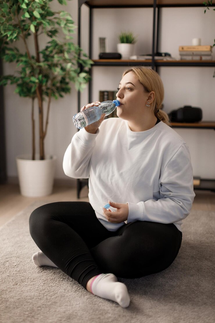 Mujer bebiendo agua después de entrenar