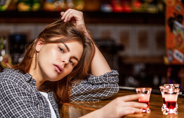 Mujer bebiendo alcohol Vaso de whisky aislado en un bar o pub en abuso de alcohol y concepto alcohólico Mujer borracha sosteniendo un vaso de whisky o ron Mujer en depresión