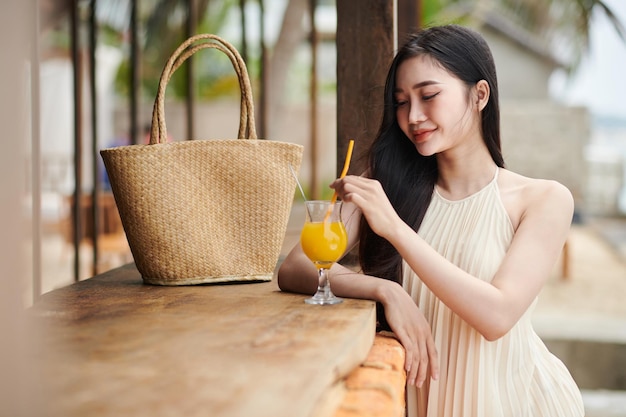 Mujer bebiendo en el bar de la playa