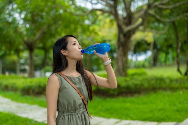 Foto mujer bebiendo una botella de agua al aire libre