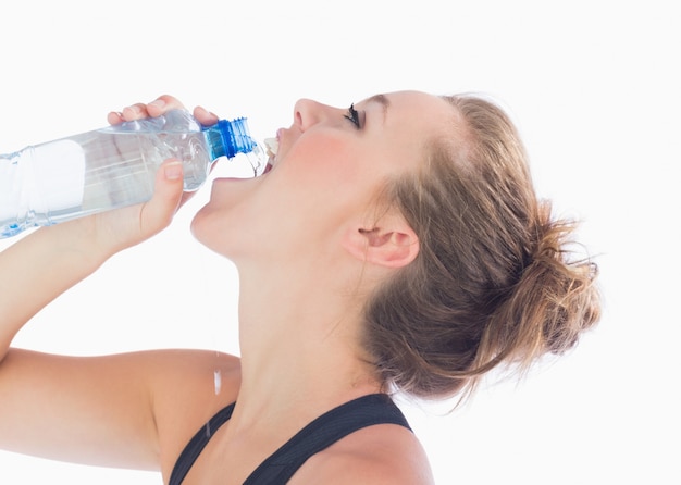 Mujer bebiendo una botella de agua después del ejercicio