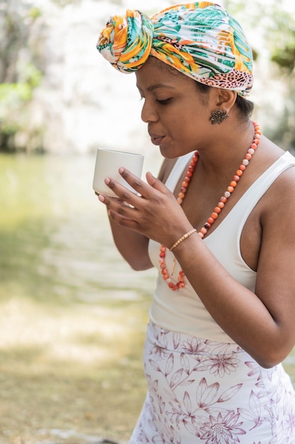 Mujer bebiendo café junto al río