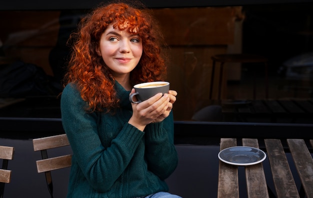 Foto mujer bebiendo chocolate caliente en el cafe