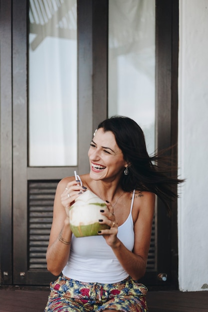 Foto mujer bebiendo un coco fresco