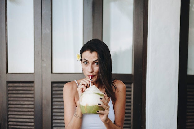 Mujer bebiendo un coco fresco