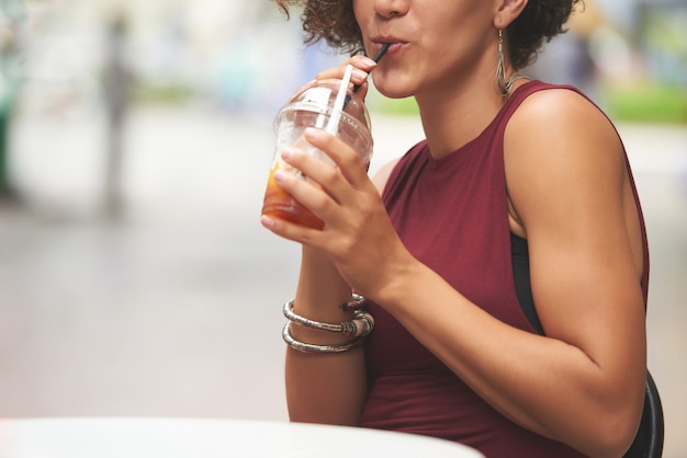 Mujer bebiendo una deliciosa bebida de frutas