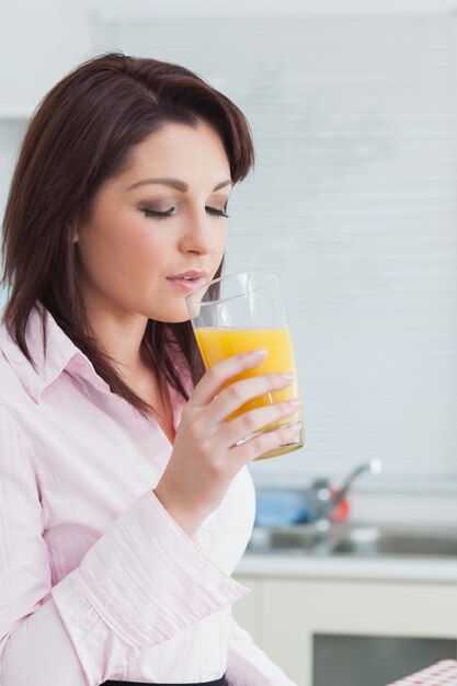 Foto mujer bebiendo jugo de naranja