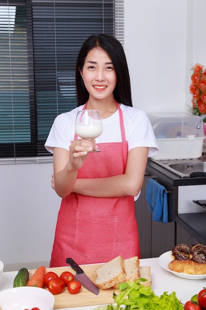 mujer bebiendo leche en la cocina