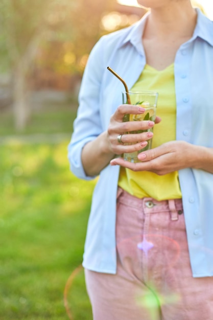 Mujer bebiendo limonada cítrica de verano con fiesta de pajitas de metal reutilizables