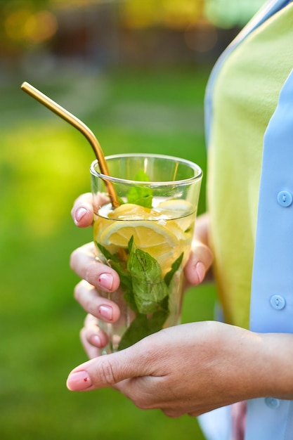 Mujer bebiendo limonada cítrica de verano con fiesta de pajitas de metal reutilizables