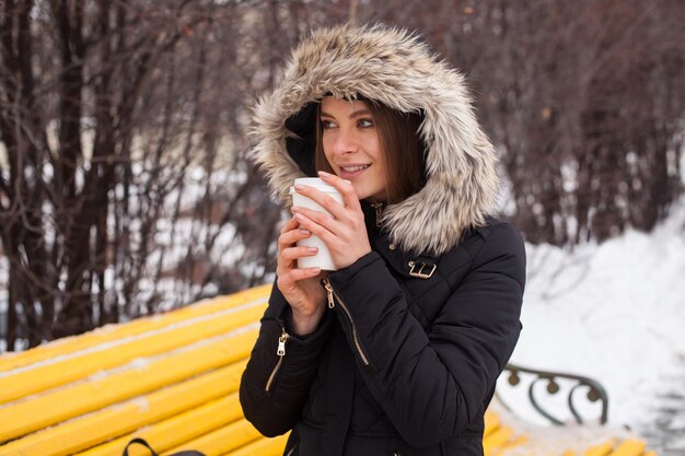 Mujer bebiendo su bebida caliente de la taza Temporada de invierno