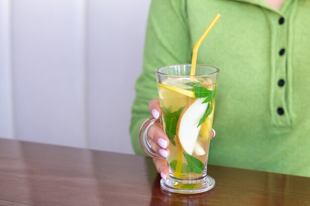 Mujer bebiendo té de frutas en la cafetería