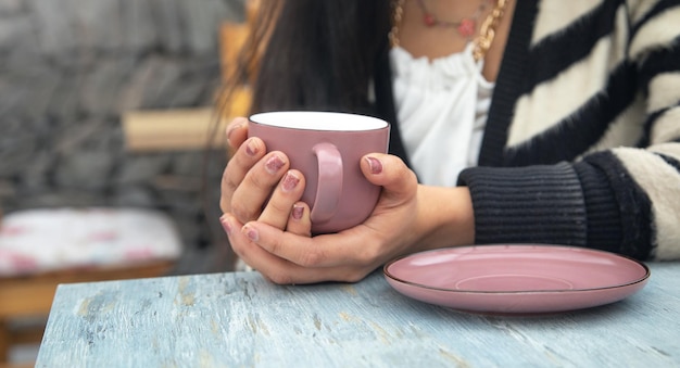 Mujer bebiendo té sabroso en la mesa del café