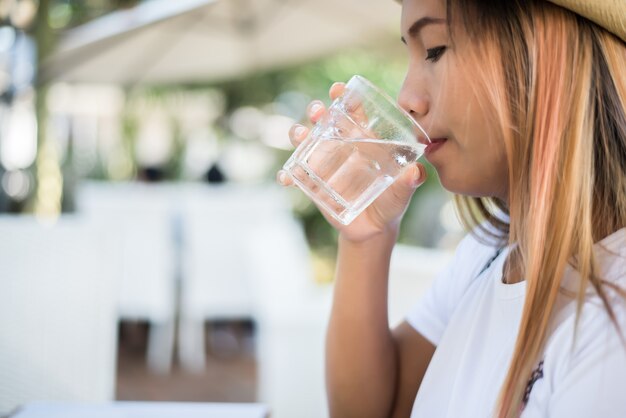 Mujer bebiendo de un vaso de agua. Bebe agua para saludable.