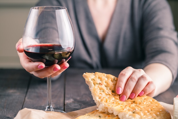 Mujer bebiendo vino y comiendo pan