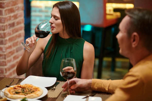 Mujer bebiendo vino en el restaurante