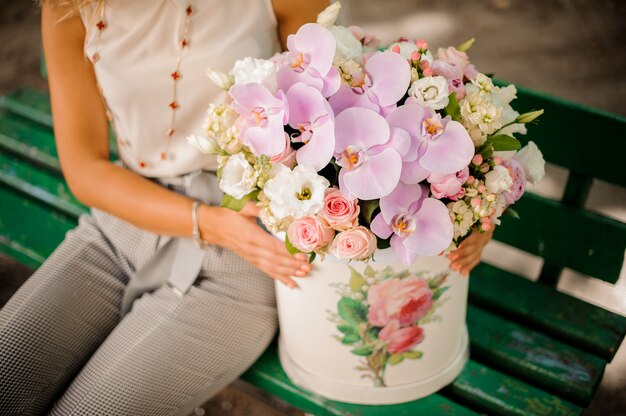 Mujer con una bella composición de hermosas flores.