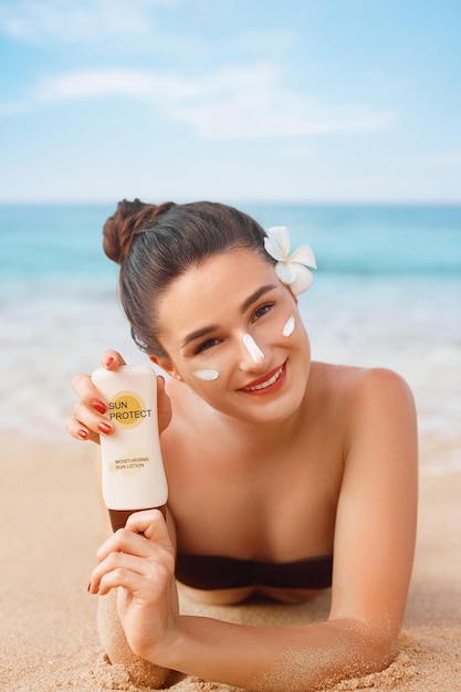 Mujer de belleza en Bikini sosteniendo botellas de protector solar en sus manos