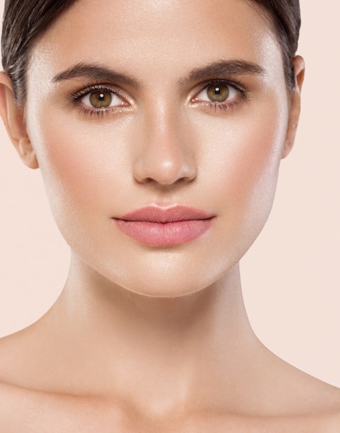 Mujer belleza cara sana piel limpia maquillaje natural belleza ojos mujer joven modelo Fondo beige.