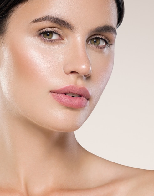 Mujer belleza cara sana piel limpia maquillaje natural belleza ojos mujer joven modelo Fondo beige.