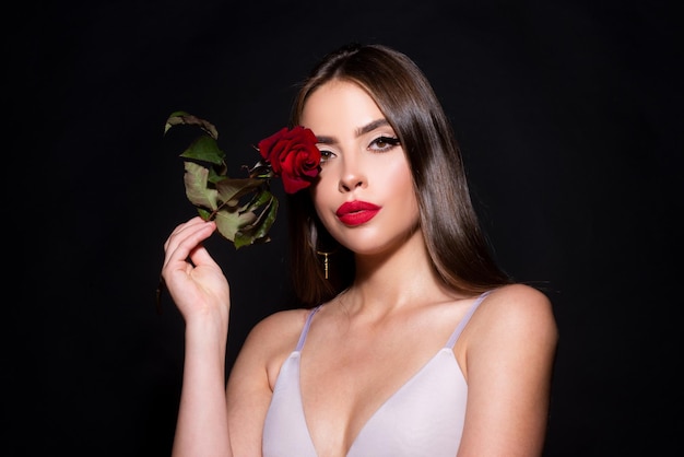 Mujer de belleza con flor de rosa hermosa chica de moda retrato de tiro en la cabeza sobre un fondo negro