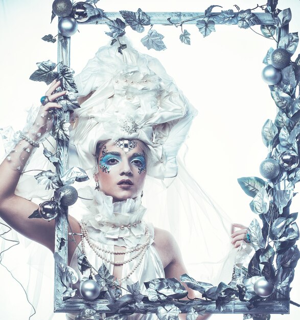 Foto mujer de belleza de invierno. maquillaje de vacaciones. reina de invierno con peinado de nieve y hielo