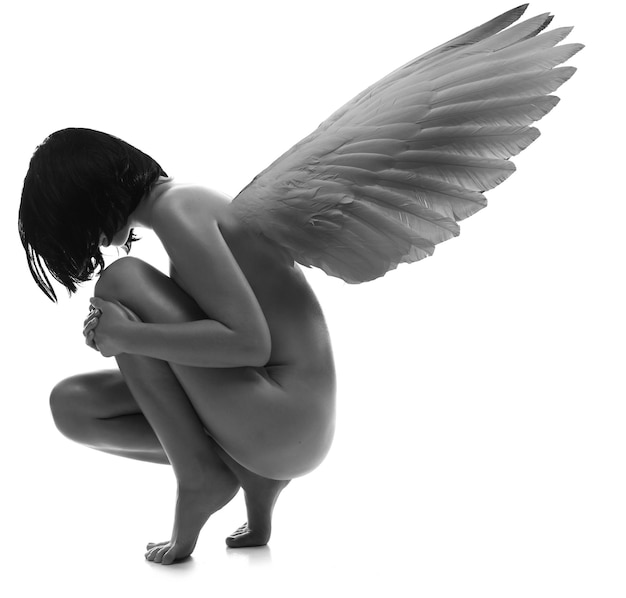 Mujer de belleza joven desnuda con alas en fondo blanco