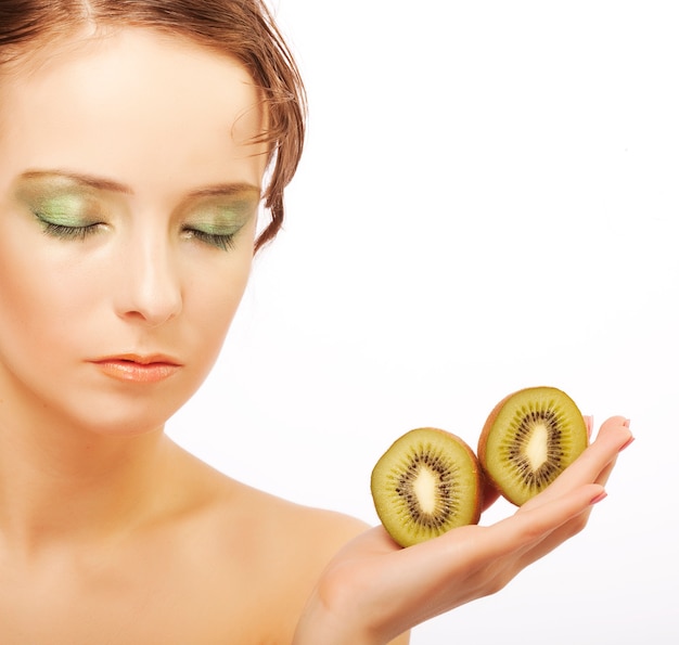 Mujer de belleza con kiwi en mano