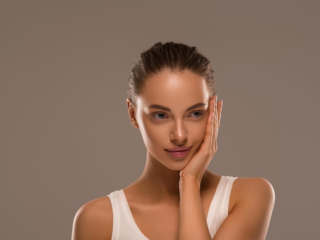 Mujer de belleza con manos naturales saludables maquillaje fondo de color de concepto de piel limpia y fresca