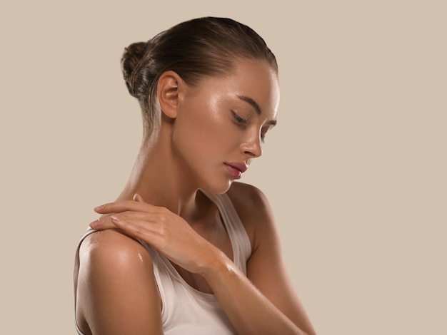 Mujer de belleza con manos naturales sanas componen la piel limpia y fresca concepto color de fondo marrón