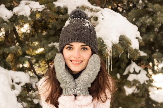 Mujer de belleza en el parque en gorro con árbol detrás