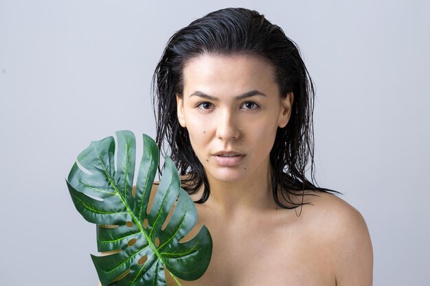 Foto mujer de belleza con retrato de hoja de palma verde natural cosméticos de maquillaje de belleza de moda