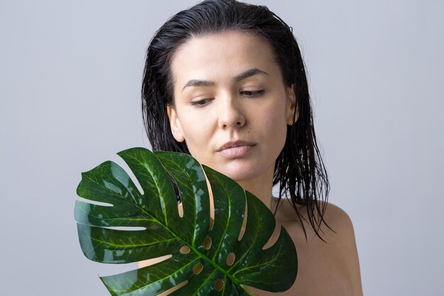 Mujer de belleza con retrato de hoja de palma verde natural Cosméticos de maquillaje de belleza de moda