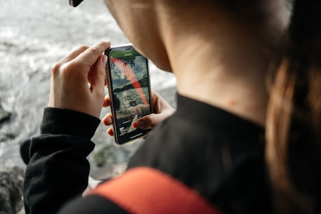 Mujer en berugu tomando fotografías del río