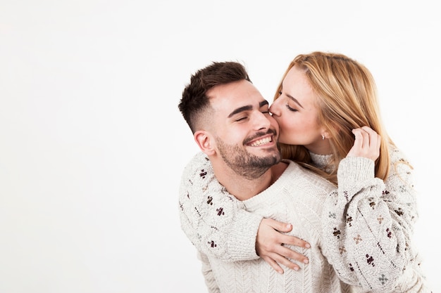 Mujer besando a hombre sonriente