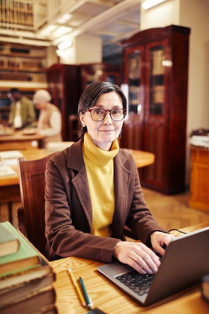 Mujer bibliotecaria sonriente en el lugar de trabajo