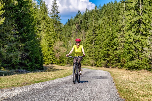 Mujer en bicicleta en el bosque