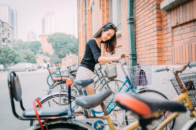 Foto mujer con bicicleta en la calle de la ciudad