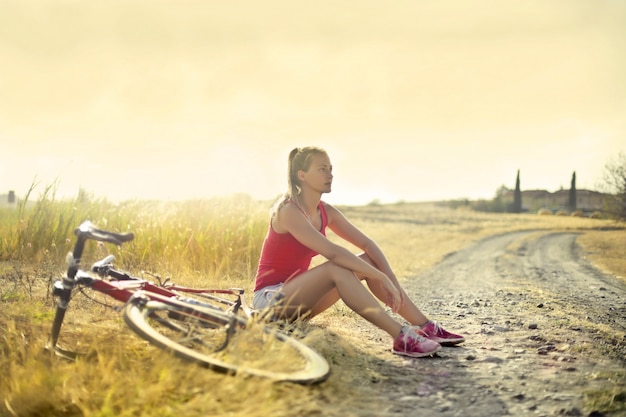 mujer con bicicleta en el campo