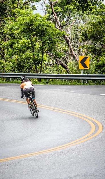 Mujer en bicicleta en la carretera de la ciudad