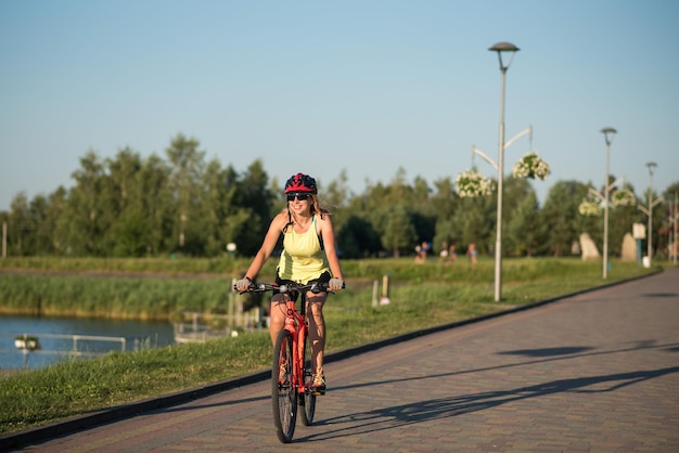 Mujer en bicicleta en el fondo del agua del lago en el parque