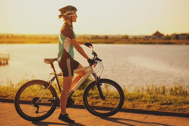 Mujer en bicicleta en el fondo del agua del lago en el parque