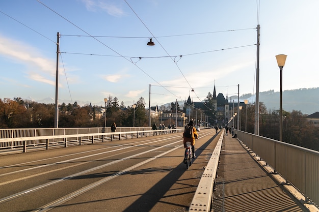 Mujer en bicicleta por el puente y el museo de Einstein en el fondo en Berna en un día soleado en Suiza