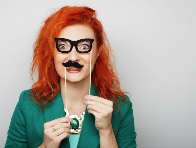 Mujer con bigote y gafas en un palo.