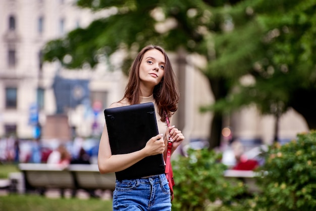 Mujer blanca años con laptop en manos al aire libre