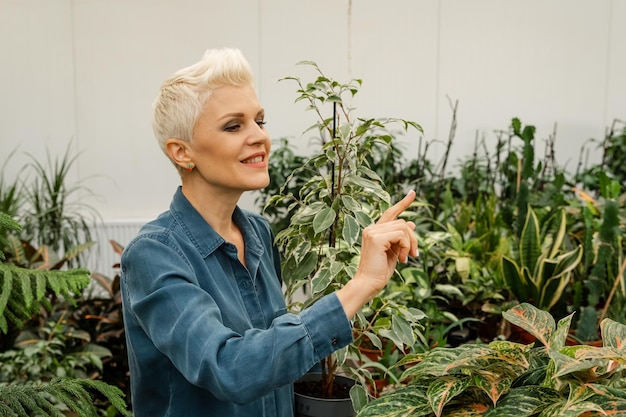 Mujer blanca feliz disfruta plantando en el espacio interior del jardín de la casa