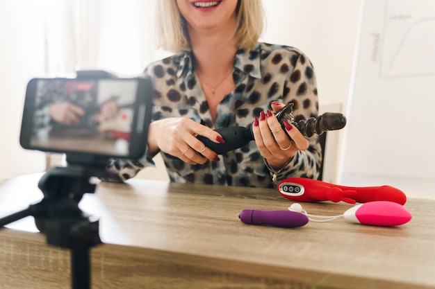 Mujer bloguera haciendo vlog y revisando diferentes juguetes sexuales