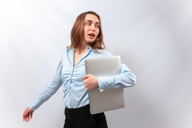 Una mujer con una blusa azul se encuentra con una computadora portátil en sus manos aislar